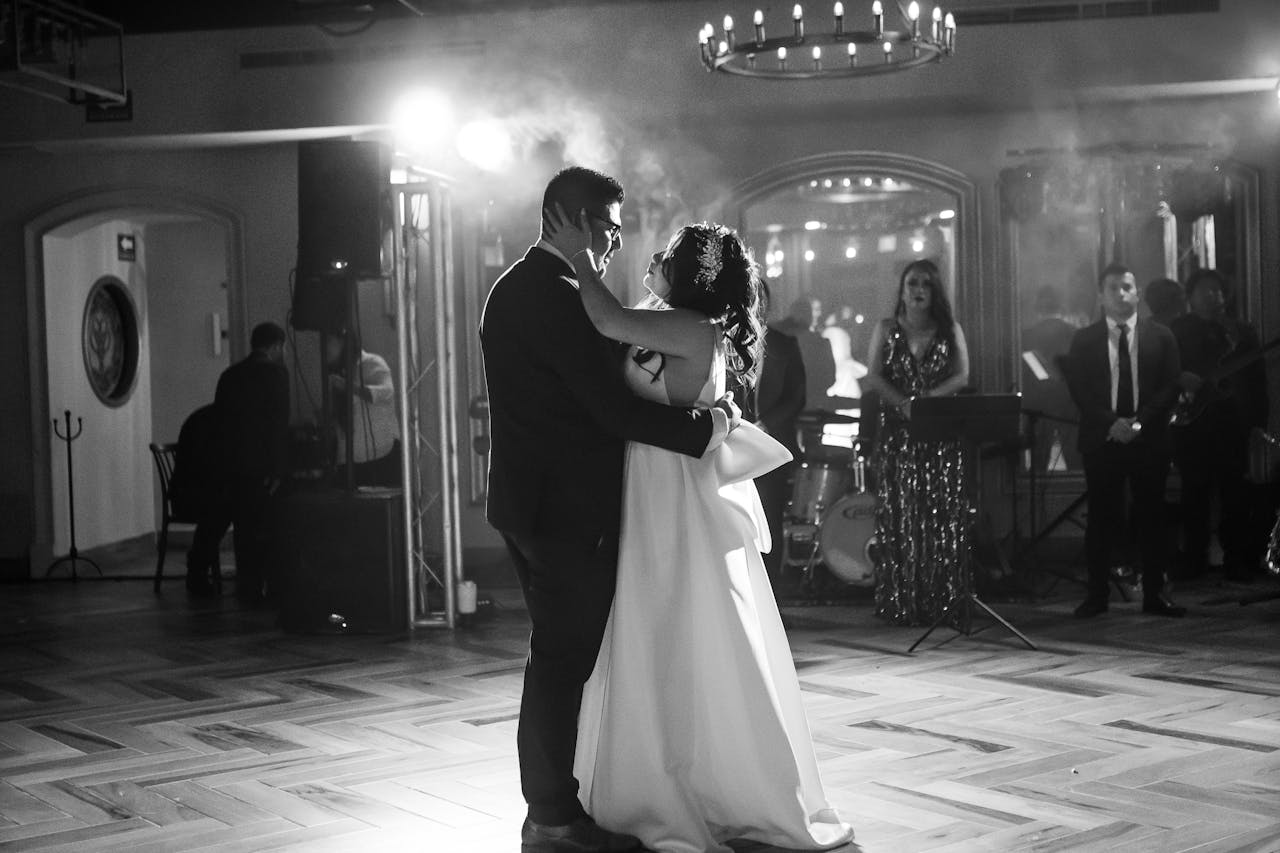 A couple shares a romantic dance at their wedding reception in black and white.