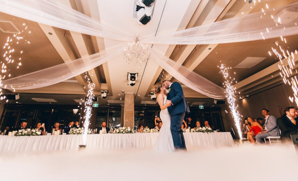 Romantic bride and groom dance surrounded by sparklers at a luxurious wedding reception.